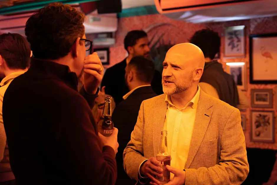 Two attendees in conversation at an evening networking event.